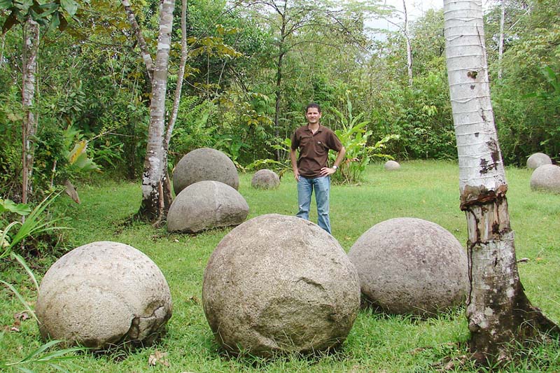 Turista junto a algunas esferas de piedra en Costa Rica