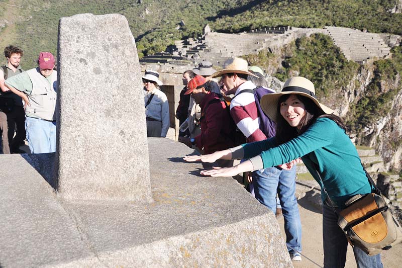 Turista sintiendo la energía del Intihuatana