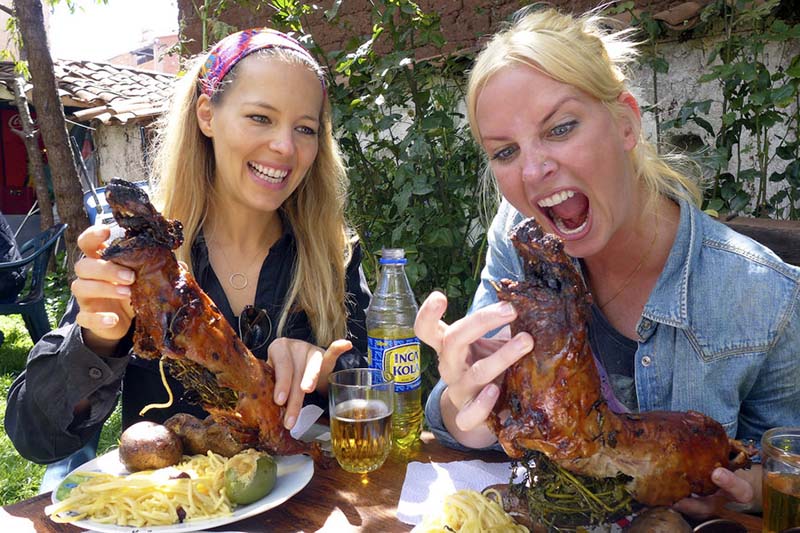 Turistas disfrutando del cuy al horno en Tipón