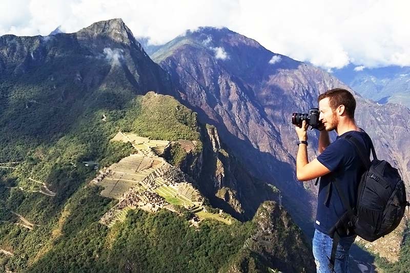 Turistas tirando fotos no topo da montanha Huayna Picchu