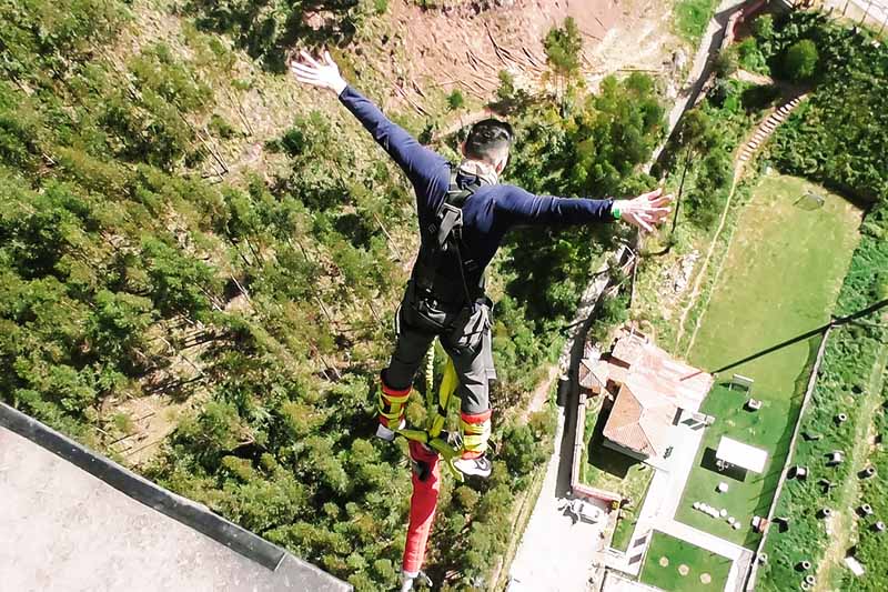 Tourist, der das Federelement springt in Cusco tut