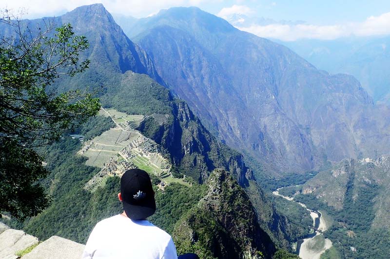 La montaña Huayna Picchu Turista observando Machu Picchu do topo da montanha Huayna Picchu