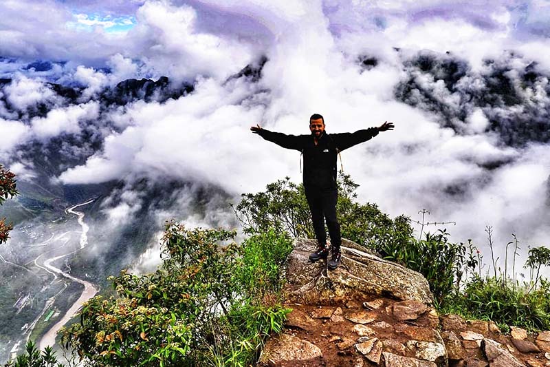 Turista entre las nubes en la montaña Machu Picchu