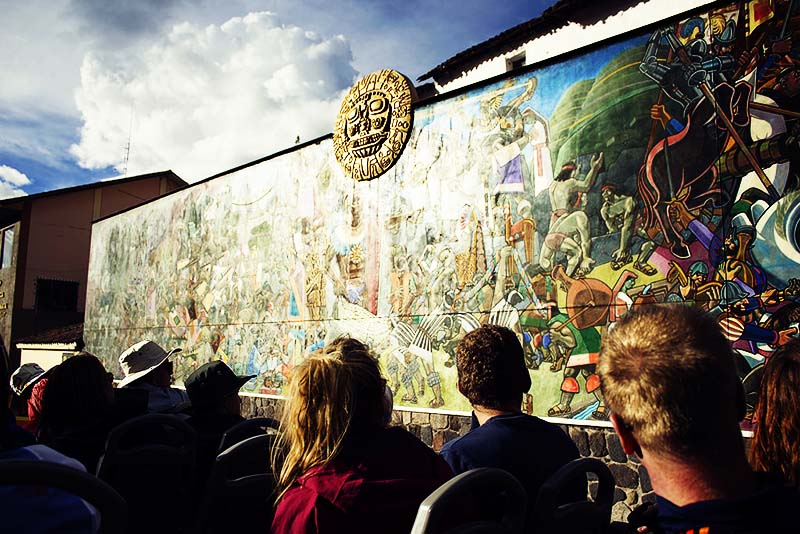 Turistas observando el mural de la historia del Cusco