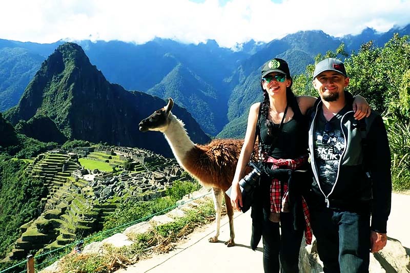 Turistas em Machu Picchu junto a uma lhama