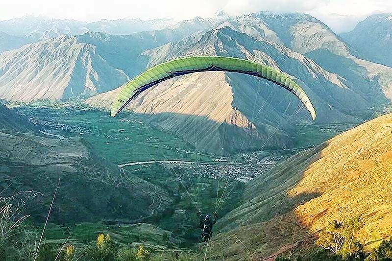 Tourist, der Gleitschirmfliegen im heiligen Tal der Inkas übt