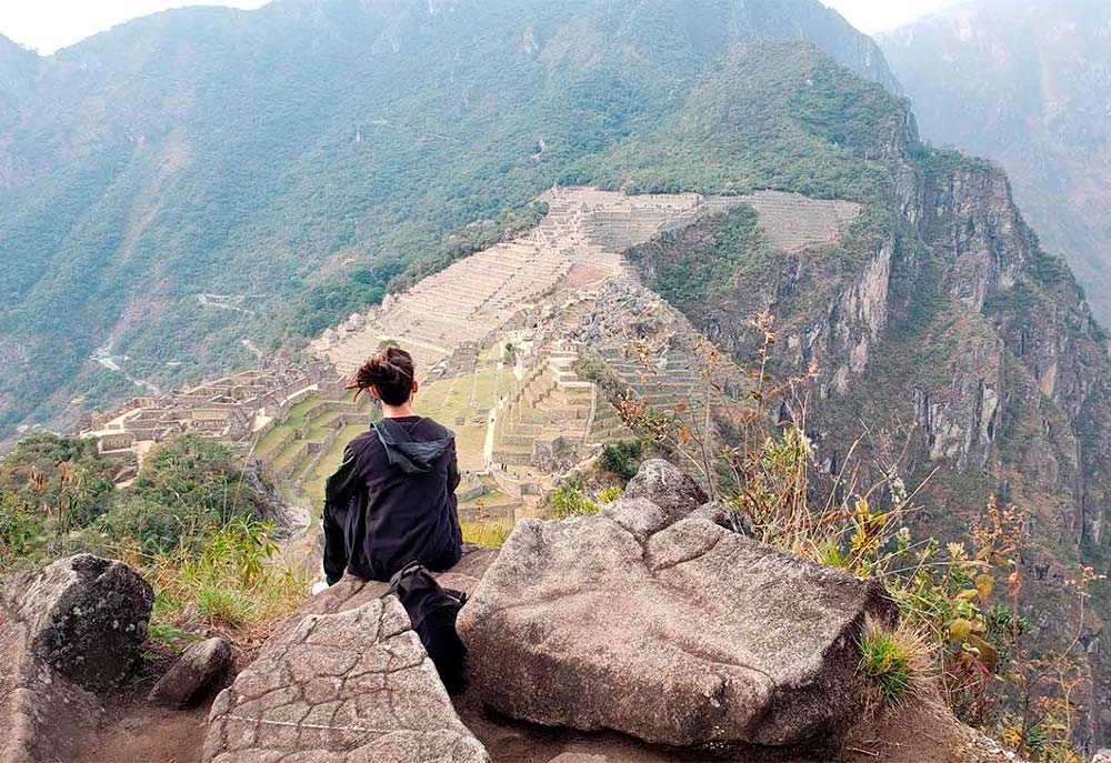 Turista observando Machu Picchu desde la Montaña Huchuypicchu