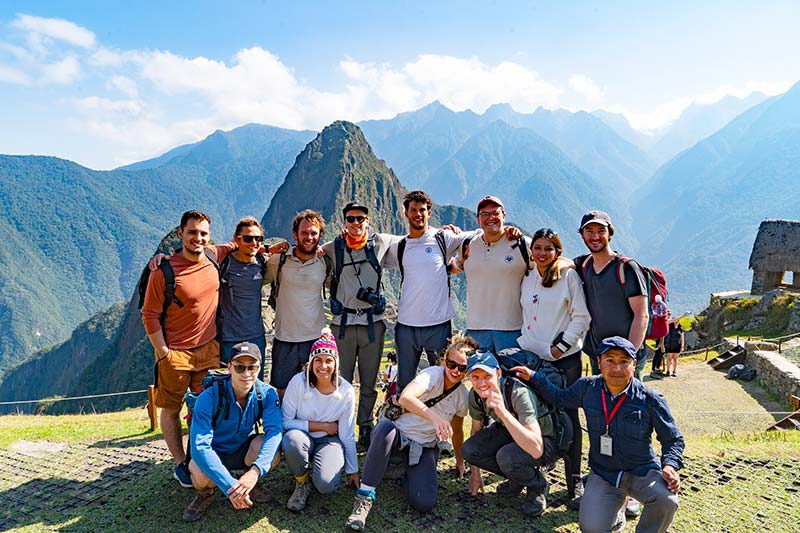 Grupo de turistas jóvenes explorando Machu Picchu