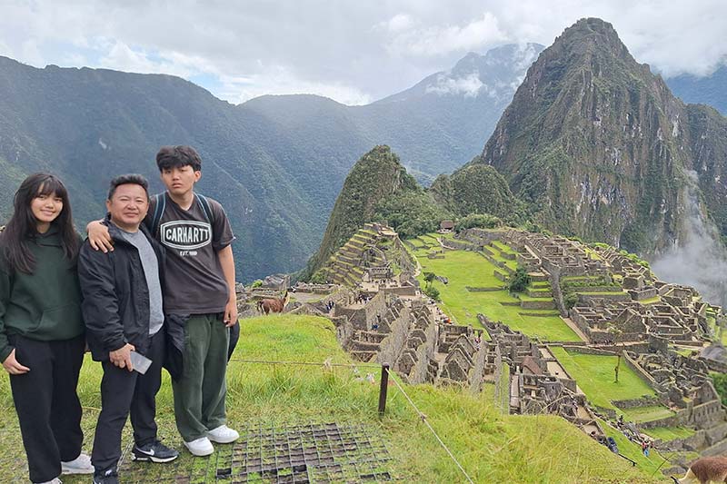 Pai e filhos apreciando a cidadela inca de Machu Picchu