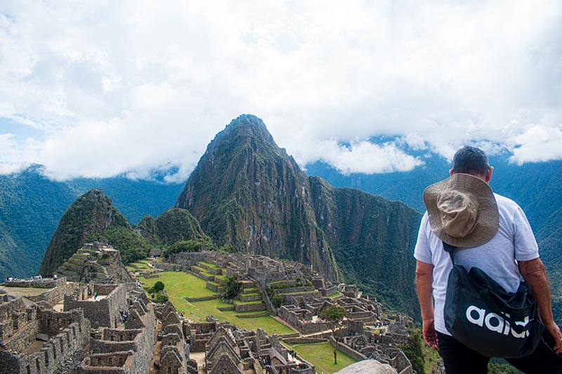 Turista observando el sitio arqueológico de Machu Picchu