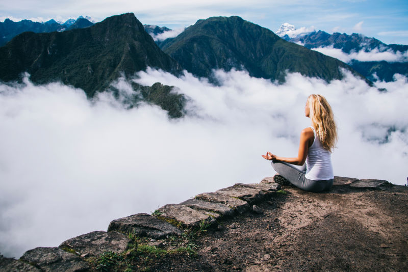 Turista meditando en la cima del Huayna Picchu