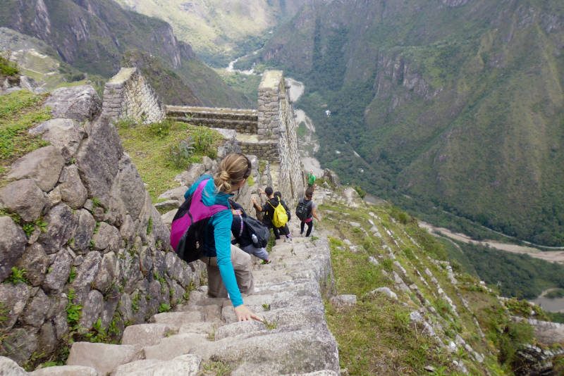 Turistas bajando por la escalera de la muerte de Huayna Picchu