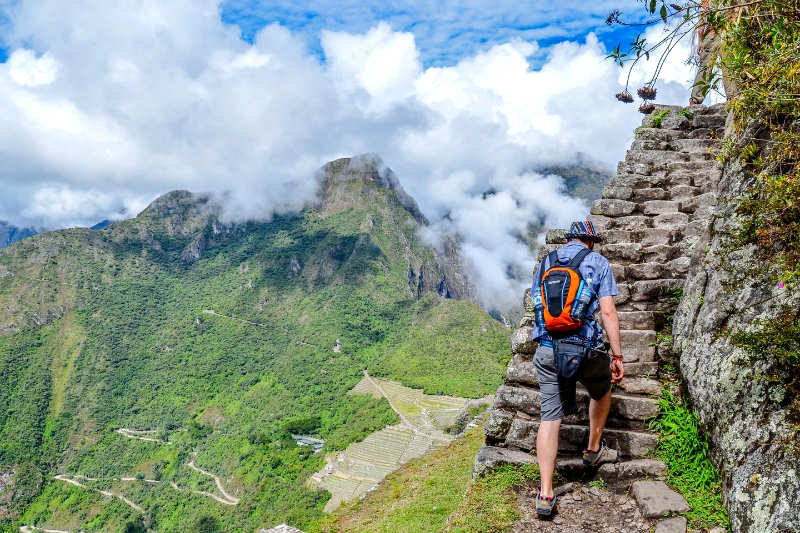 Turista subiendo a Huayna Picchu por las escalinatas de piedra