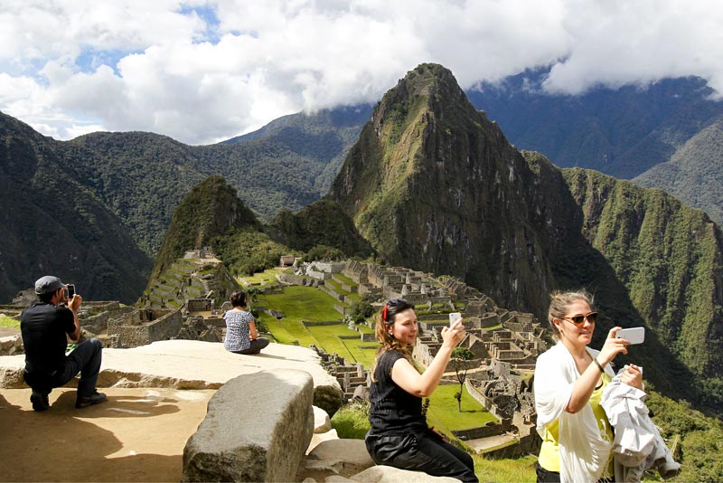 Turistas tomando fotos en Machu Picchu