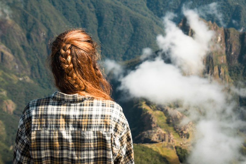 Viajera observando la ciudadela inca desde la Montaña Machu Picchu