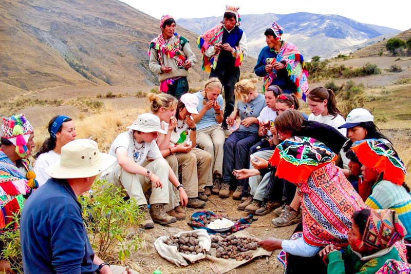 Turistas conviviendo con personas locales y probando la huatia