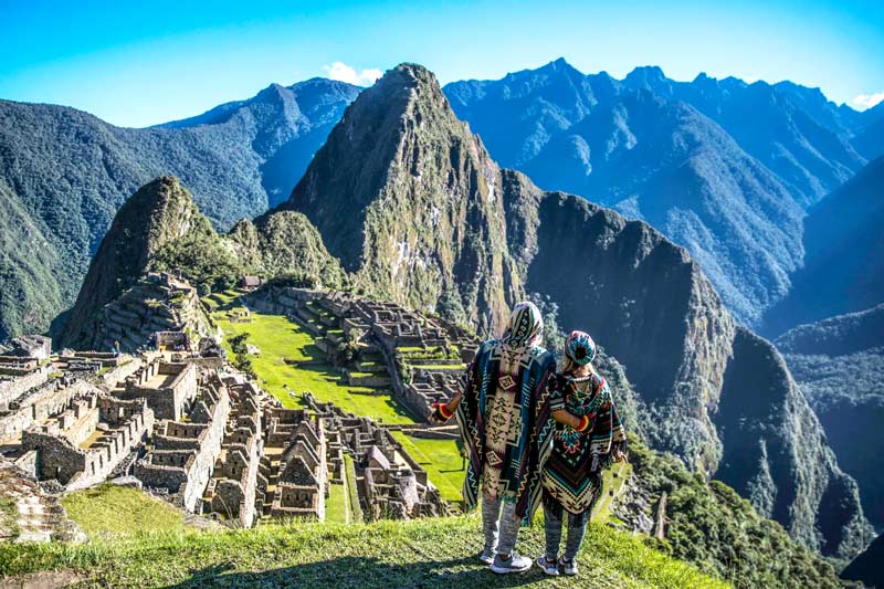 Pareja de turistas observando las construcciones de Machu Picchu