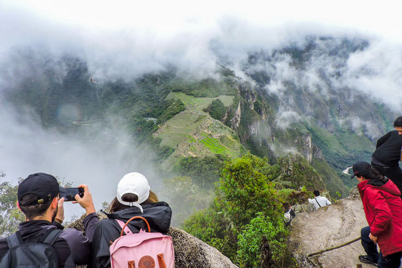 Turistas observando a cidadela inca de Machu Picchu