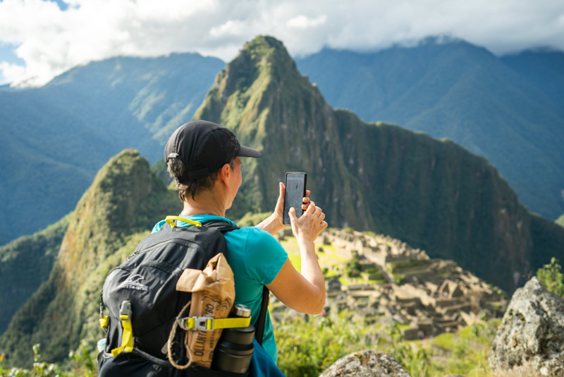 Tourist photographing the Inca citadel of Machu Picchu
