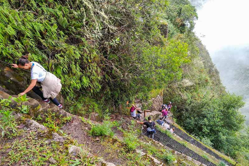 Tourists climbing the steps of Huayna Picchu Mountain