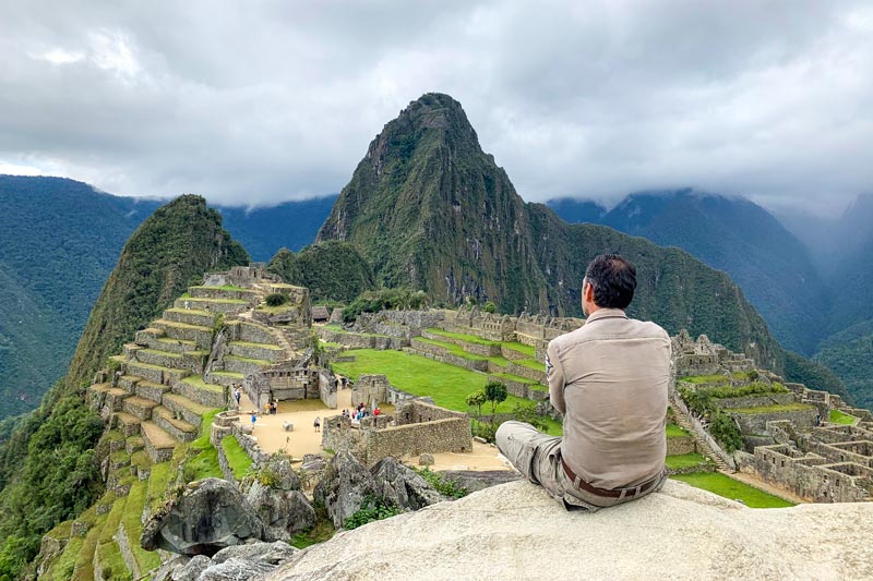 Turista observando a cidadela inca de Machu Picchu