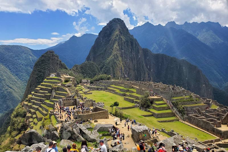 Visitantes recorriendo las construcciones de Machu Picchu