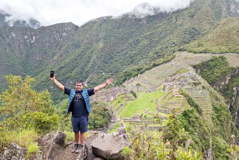 Visitante no topo da montanha Huchuy Picchu